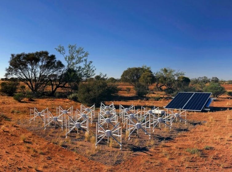 A collection of 16 dipole antennas on red outback sands surrounded by shrubs